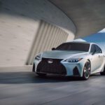 Lexus sedan driving past curved modern building