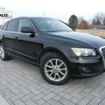 Black Audi SUV parked on brick driveway