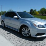Silver Subaru sedan parked on brick driveway