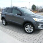 Gray crossover parked on brick driveway