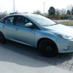 Light silver compact sedan parked on pavers
